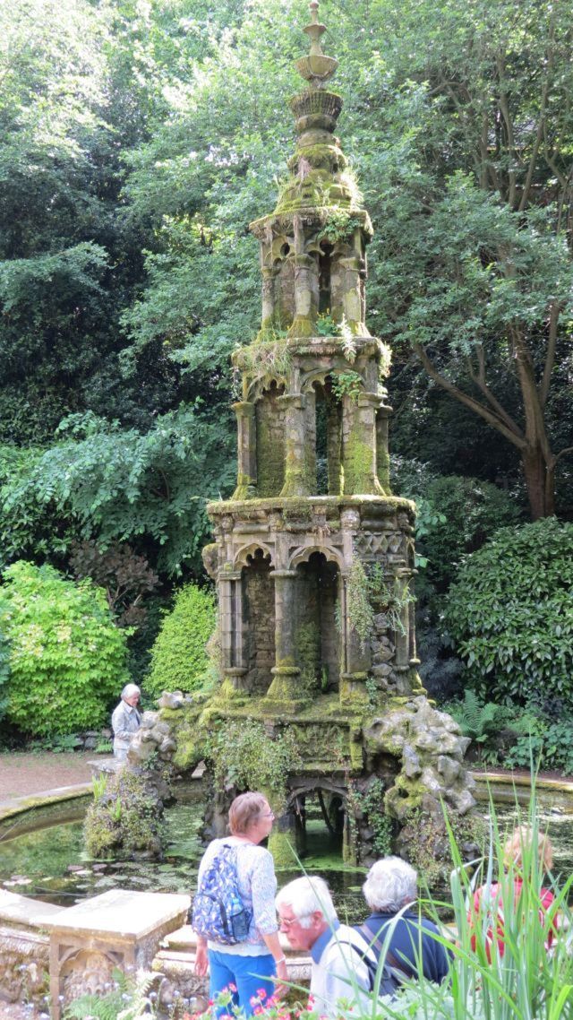 Multi-tiered stone structure in walled pond with people looking.