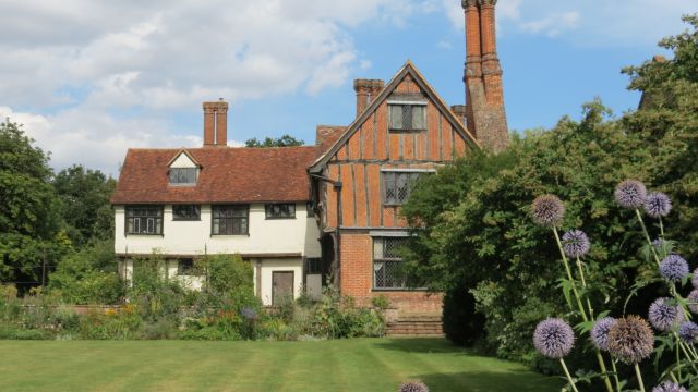 Country house with lawn and flower beds in front.