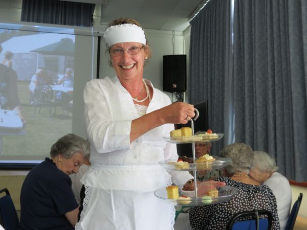 Waitress with tall cake stand.