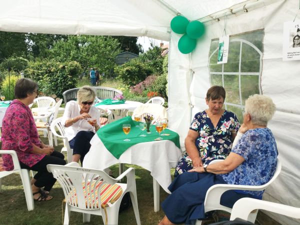 Pimms, Raffle and a Quiz in President Pat Swindell's garden. More members at table with view of garden behind.